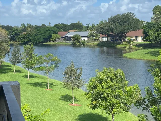 an aerial view of a house with a yard and lake view