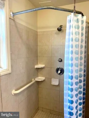 a view of an empty room with wooden floor and a ceiling fan