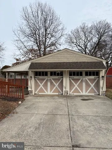 a view of wooden house with large space and trees