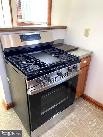 a kitchen with granite countertop stainless steel appliances a sink stove and window