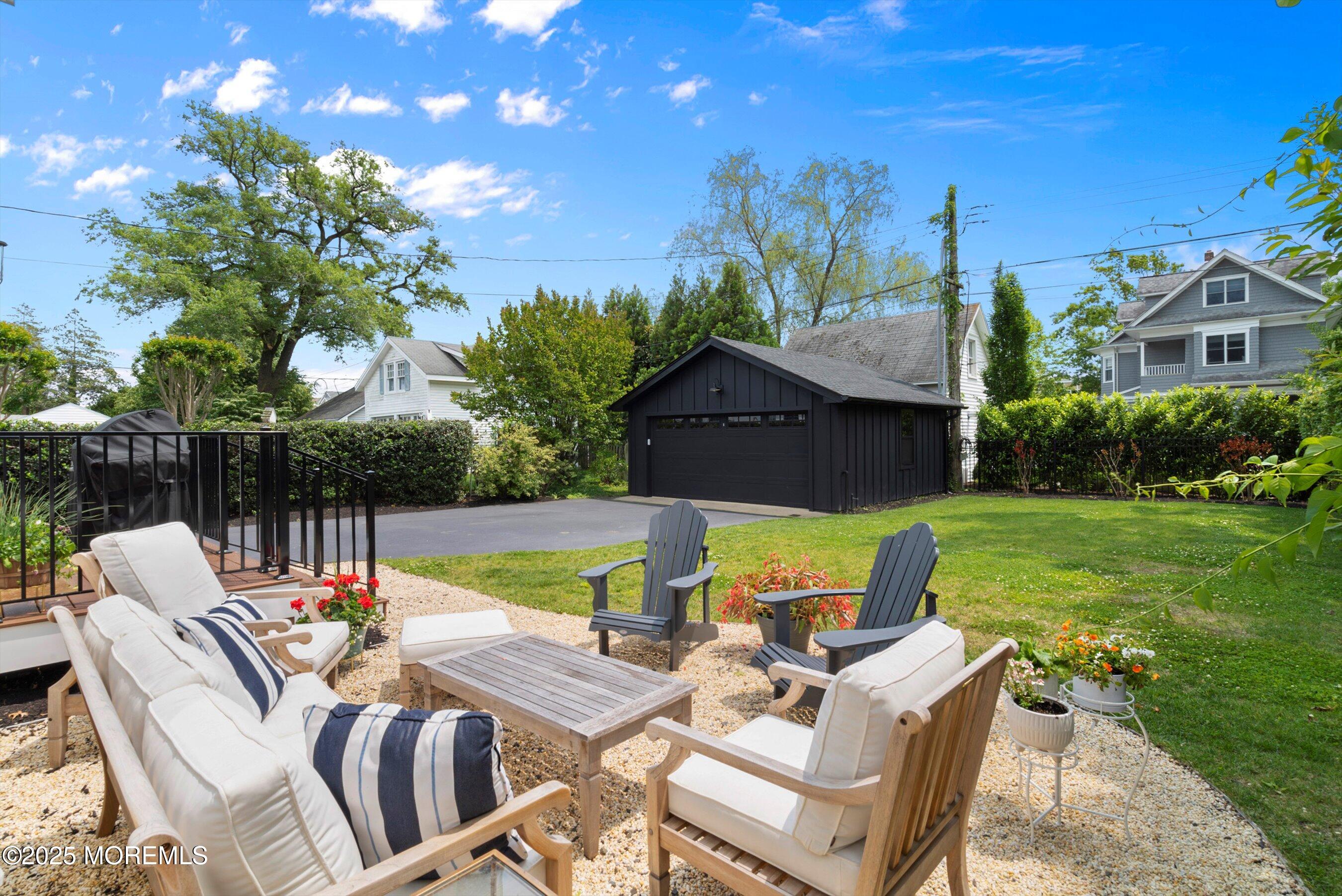 405 Ludlow Avenue Spring Lake, NJ 07762 - Photo 39 of 42 a view of a patio with couches chairs and a table and chairs with wooden floor and fence