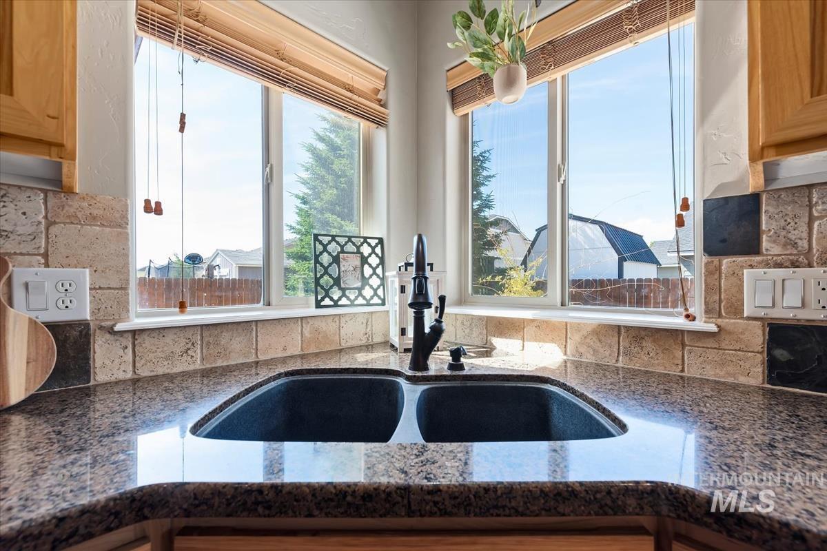 640 Southwest Miner Street Mountain Home, ID 83647 - Photo 32 of 35 Corner kitchen sink with dual basins, black faucet, and granite-style countertop