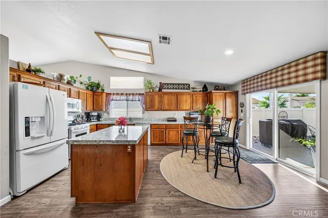a view of a dining room with furniture a rug and wooden floor