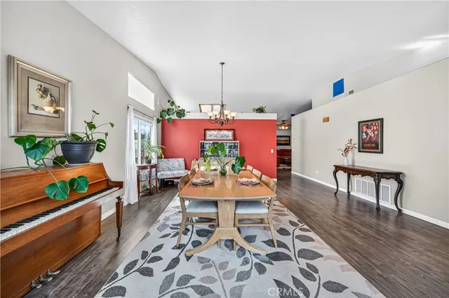 a living room with furniture dining table wooden floor and a refrigerator