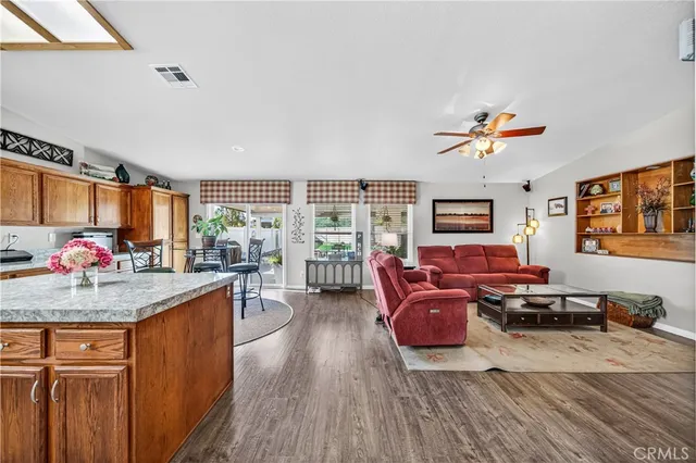 a kitchen with stainless steel appliances kitchen island granite countertop a table chairs and a refrigerator