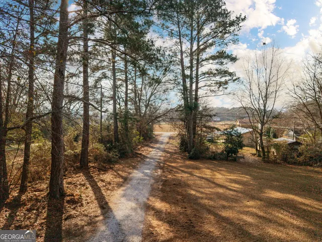 a view of a kitchen and an empty room with wooden floor and a kitchen