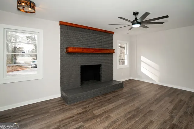 a kitchen with granite countertop a stove top oven a sink dishwasher and a refrigerator with wooden floor