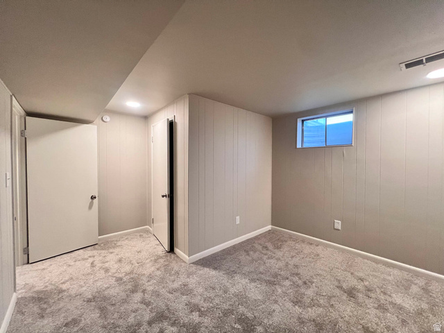 8097 South 535 East Sandy, UT 84070 - Photo 11 of 15 Room featuring light grey vertical paneling, plush grey carpet, and a horizontal window