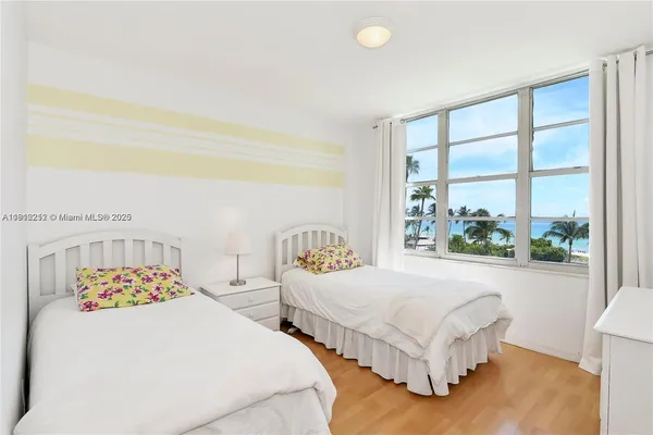 a bedroom with two beds and a large window