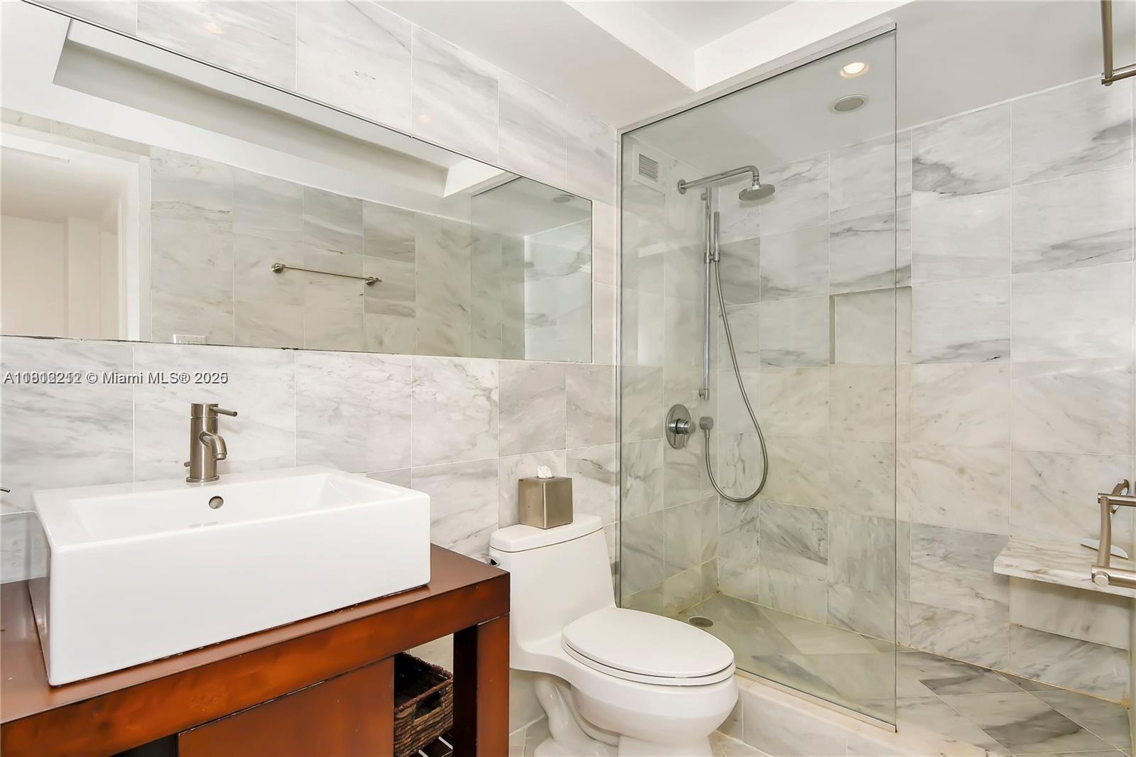 5151 Collins Avenue, Unit 619 Miami Beach, FL 33140 - Photo 14 of 16 a bathroom with a sink toilet and shower