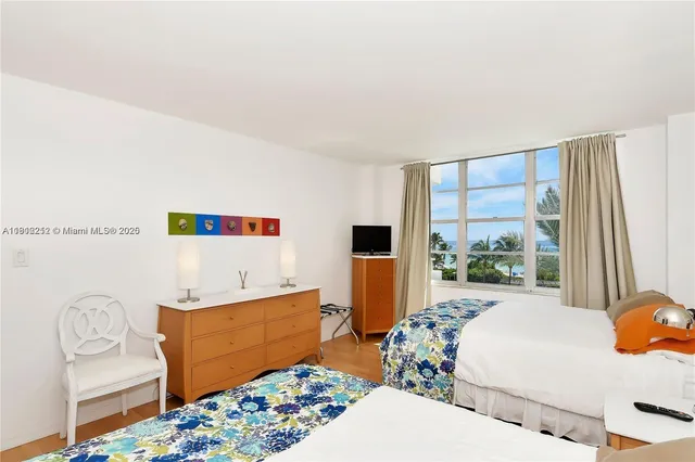 a bedroom with furniture and a large window