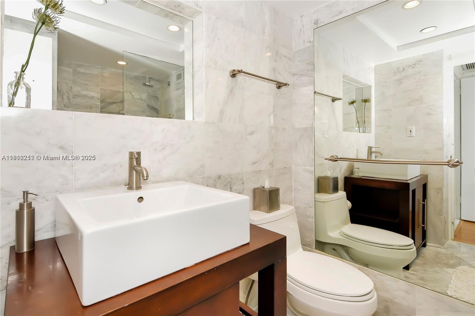 5151 Collins Avenue, Unit 619 Miami Beach, FL 33140 - Photo 5 of 16 a bathroom with a sink a toilet and shower