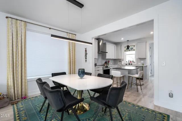 a kitchen with stainless steel appliances granite countertop a sink dishwasher a refrigerator and a stove with wooden floor