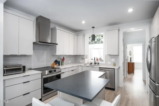 a kitchen with a sink a refrigerator and cabinets