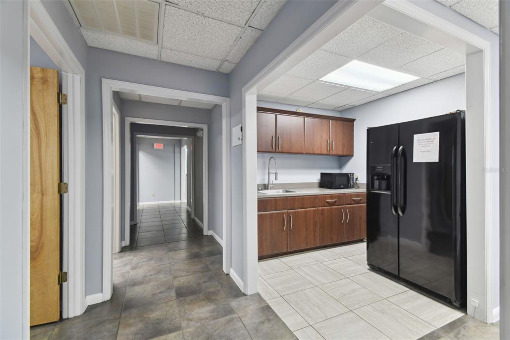 701 Enterprise Road East, Unit 100 Safety Harbor, FL 34695 - Photo 23 of 96 a kitchen with stainless steel appliances granite countertop a refrigerator and a sink