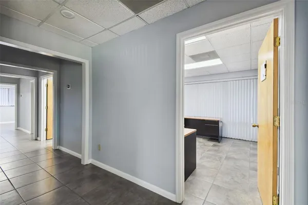 a view of a hallway with wooden floor and a living room