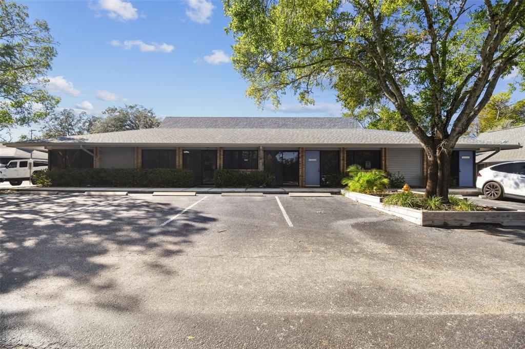 701 Enterprise Road East, Unit 100 Safety Harbor, FL 34695 - Photo 3 of 96 a view of a white house with a large tree and yard