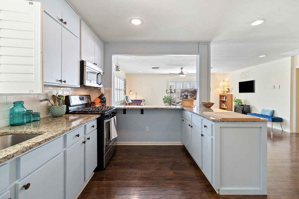 4607 Kitty Avenue Austin, TX 78721 - Photo 10 of 33 a kitchen with granite countertop white cabinets and white appliances