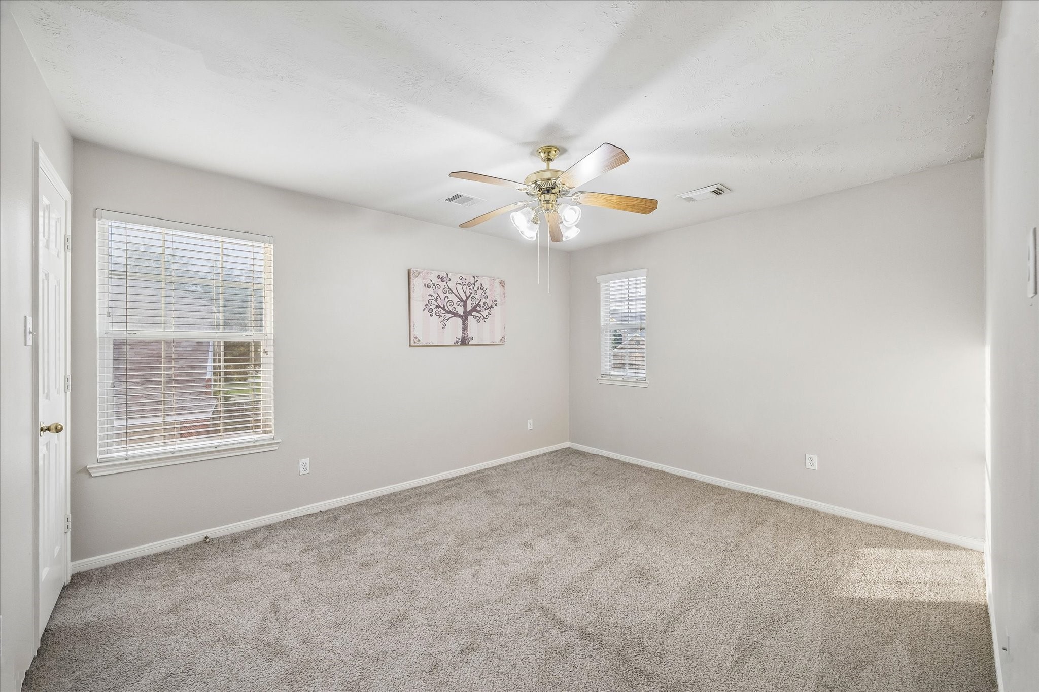 10307 Turrett Point Lane Houston, TX 77064 - Photo 9 of 12 an empty room with windows and fan