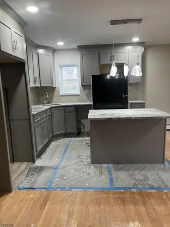 a kitchen with stainless steel appliances granite countertop a refrigerator a stove and a sink