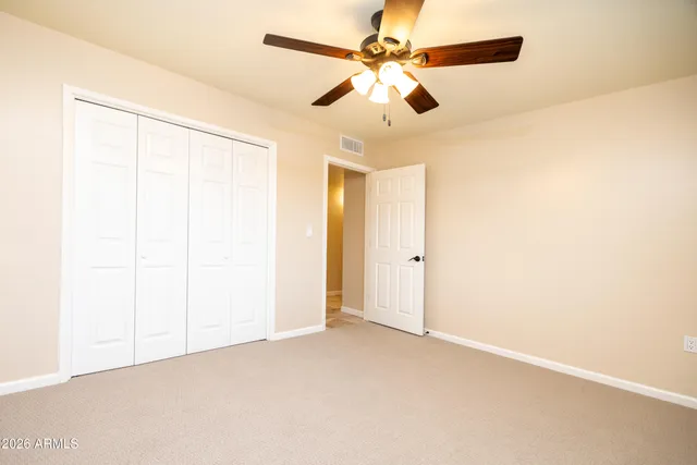 an empty room with a ceiling fan and a window