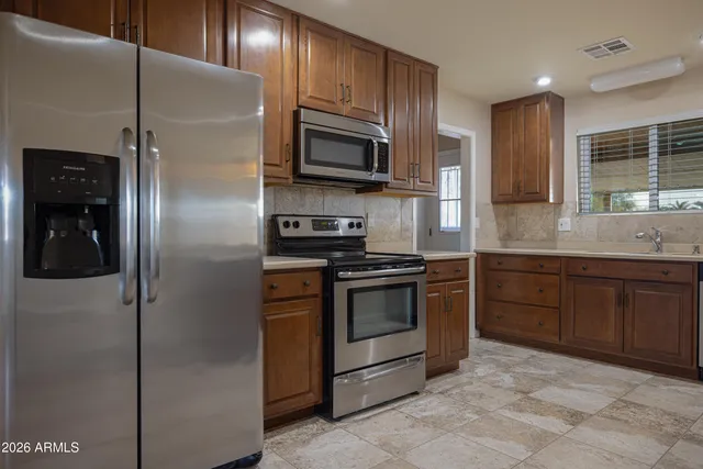 a kitchen with stainless steel appliances granite countertop a refrigerator and a sink