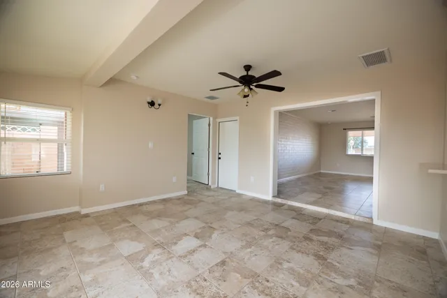 a view of a big room with wooden floor and a chandelier fan