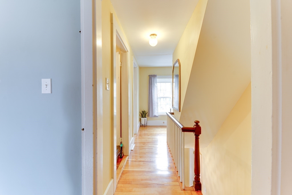 506 Washington Street Dedham, MA 02026 - Photo 15 of 28 a view of a hallway with wooden floor and staircase