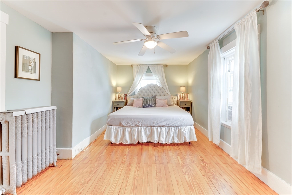 506 Washington Street Dedham, MA 02026 - Photo 19 of 28 a bedroom with a bed and a chandelier