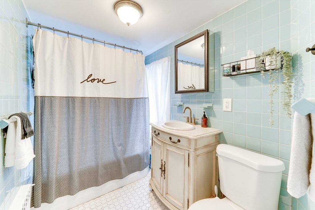 506 Washington Street Dedham, MA 02026 - Photo 24 of 28 a bathroom with a sink a toilet and a mirror