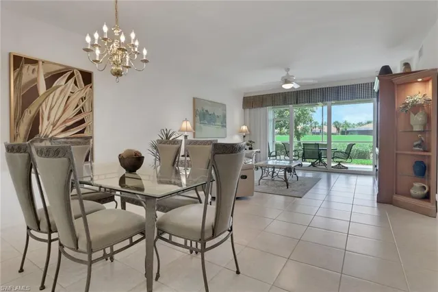 a dining room filled chandelier and glass door