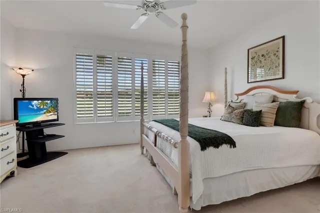 a bedroom with a bed and a flat tv screen on the dresser