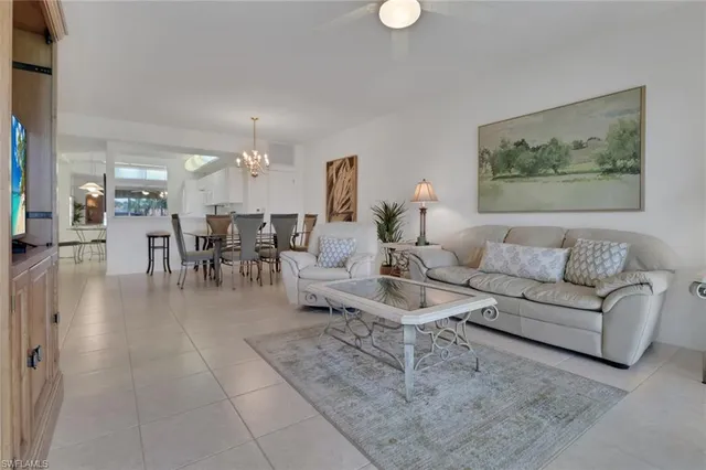 a living room with furniture and a dining table with kitchen view