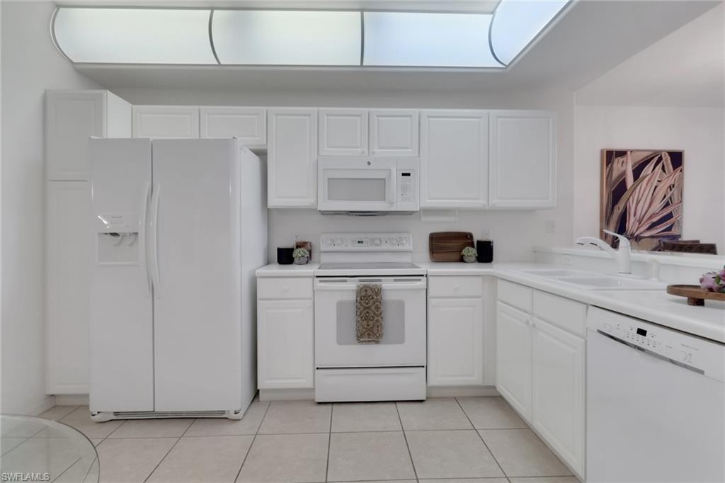 23790 Clear Spring Court, Unit 1603 Estero, FL 34135 - Photo 6 of 39 a kitchen with white cabinets and white appliances
