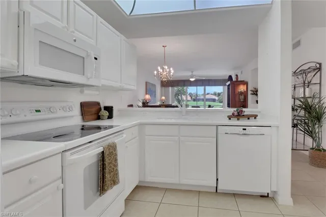 a kitchen with white cabinets and white appliances