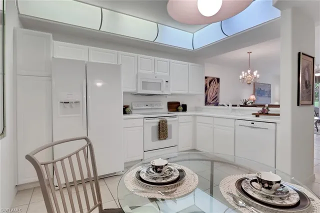 a kitchen with stainless steel appliances kitchen island granite countertop a table chairs and a refrigerator