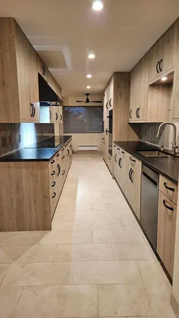 a large kitchen with stainless steel appliances granite countertop a stove and a sink