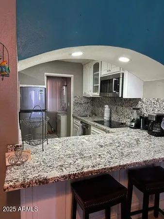 a kitchen with stainless steel appliances granite countertop a sink and a stove