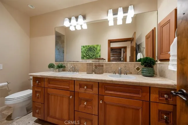 a bathroom with a granite countertop toilet sink and mirror
