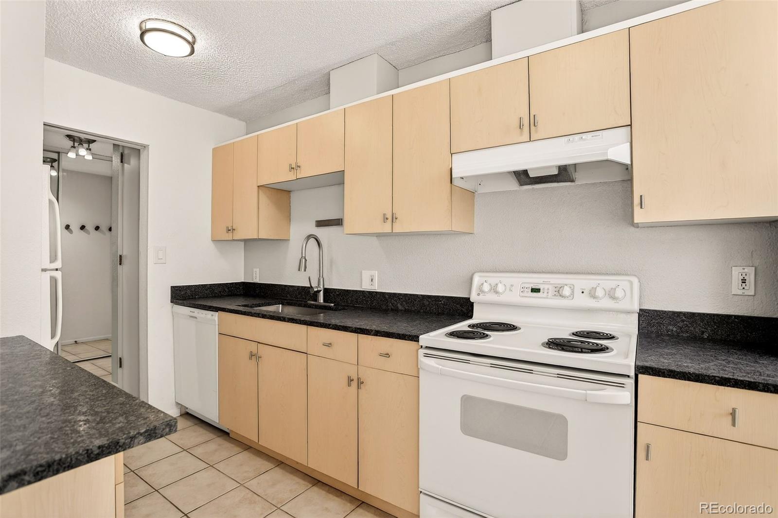 2500 South York Street, Unit 401 Denver, CO 80210 - Photo 13 of 30 a kitchen with granite countertop a sink a stove and cabinets