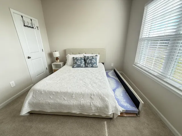 a large bed sitting in a bedroom next to a window