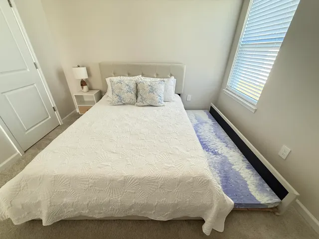 a large bed sitting in a bedroom next to a window