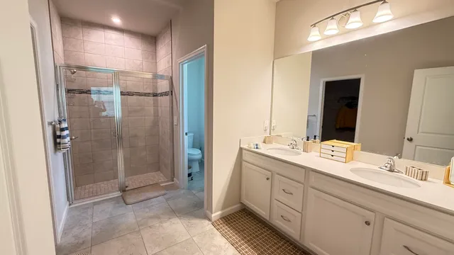 a spacious bathroom with a shower sink and mirror