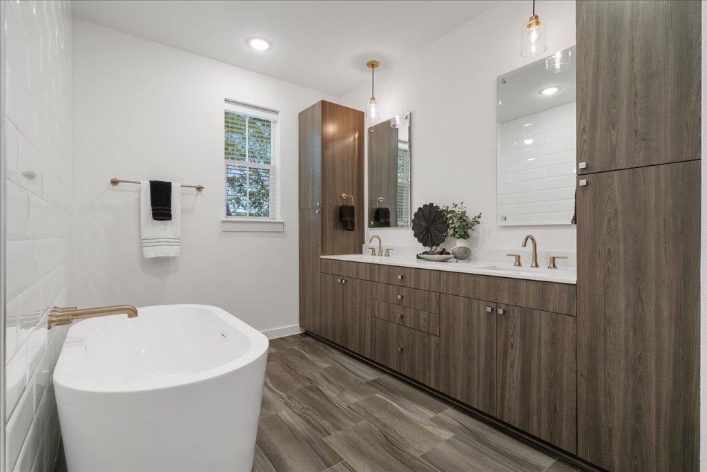 2624 Metcalfe Road, Unit 10 Austin, TX 78741 - Photo 14 of 27 Bathroom with double vanity, a soaking tub, and recessed lighting