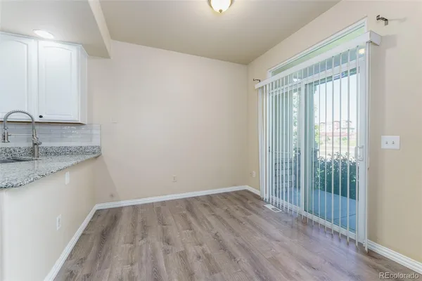 a view of kitchen with granite countertop window and wooden floor