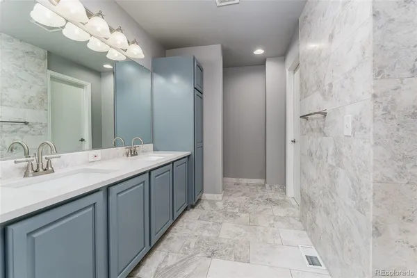 a bathroom with a double vanity sink mirror and shower