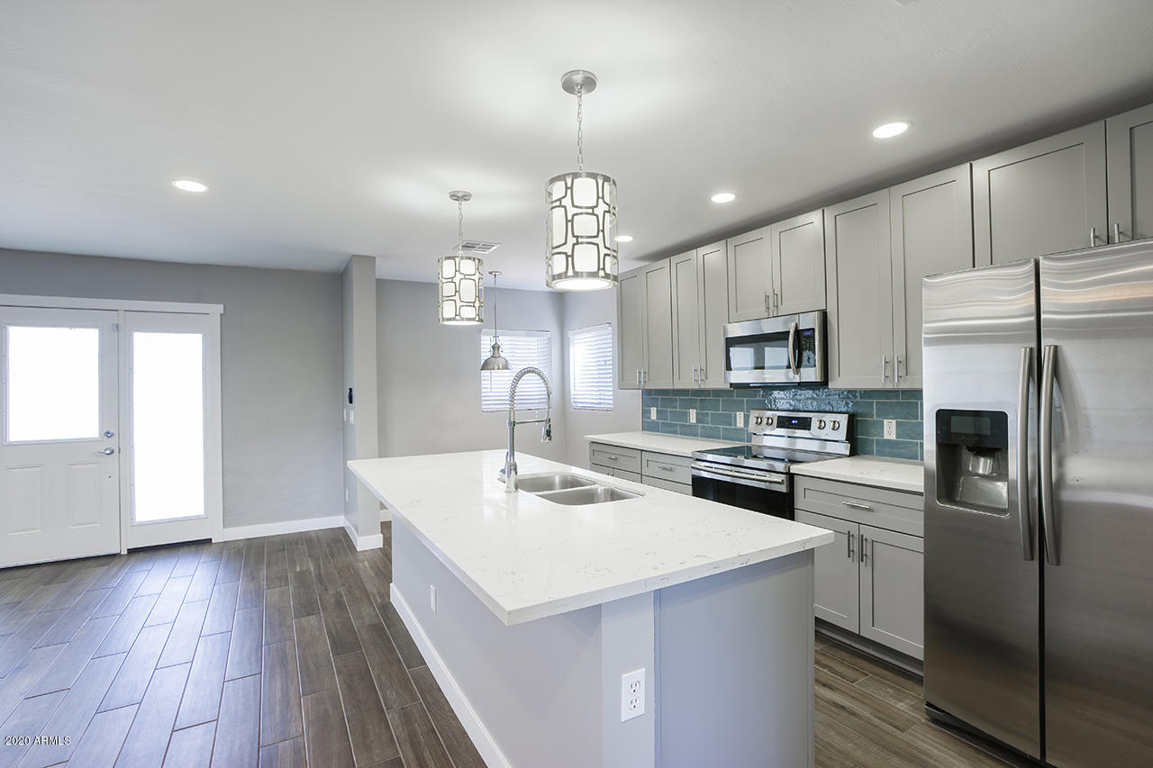 1423 East Granada Road Phoenix, AZ 85006 - Photo 9 of 25 a kitchen that has a lot of white cabinets and stainless steel appliances