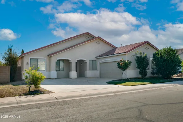 a front view of a house with a yard and potted plants