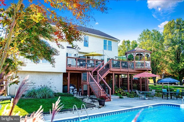 a patio with table and chairs and potted plants