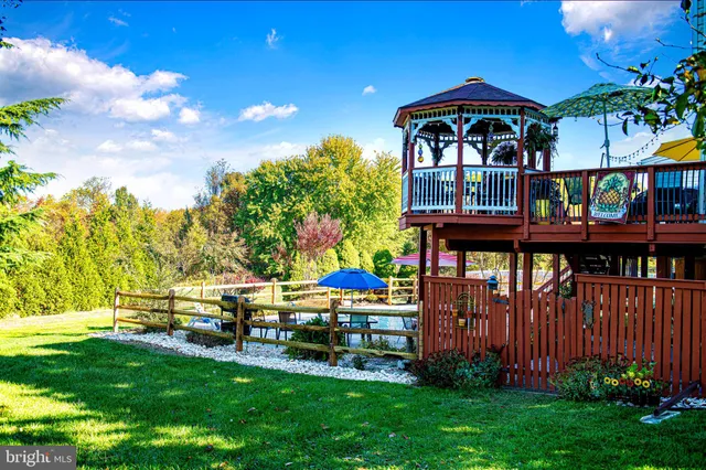 a view of swimming pool with a bench and some trees